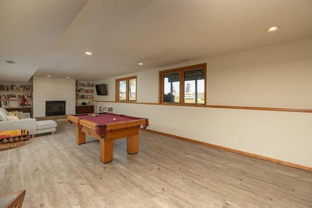 recreation room featuring billiards, a large fireplace, and light wood-type flooring