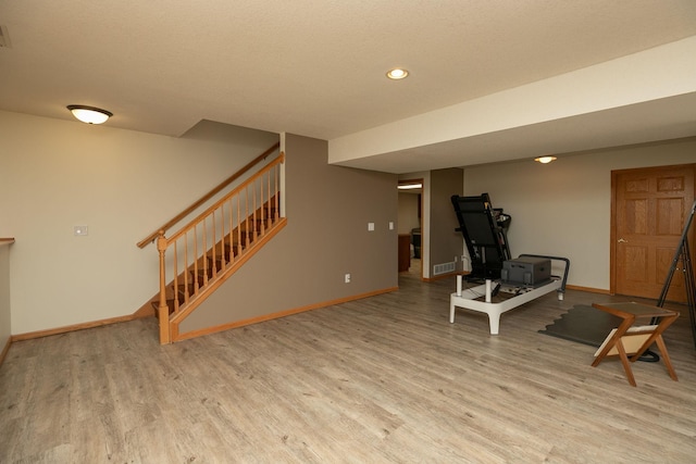 workout area with light hardwood / wood-style floors