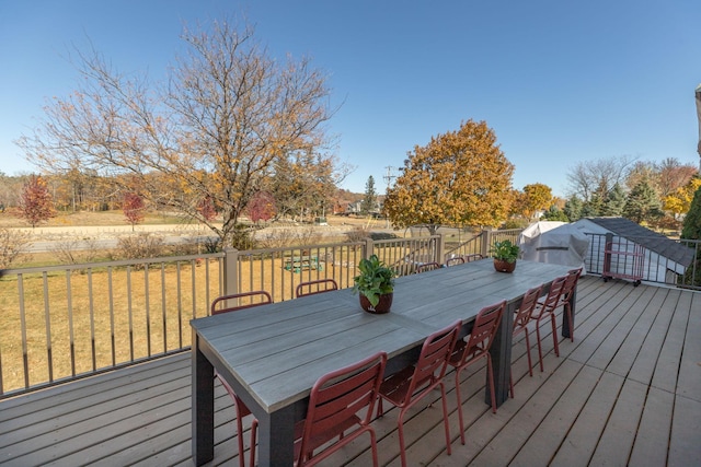 wooden deck with an outdoor structure and a lawn