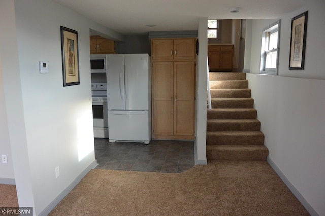 kitchen featuring dark carpet and white appliances