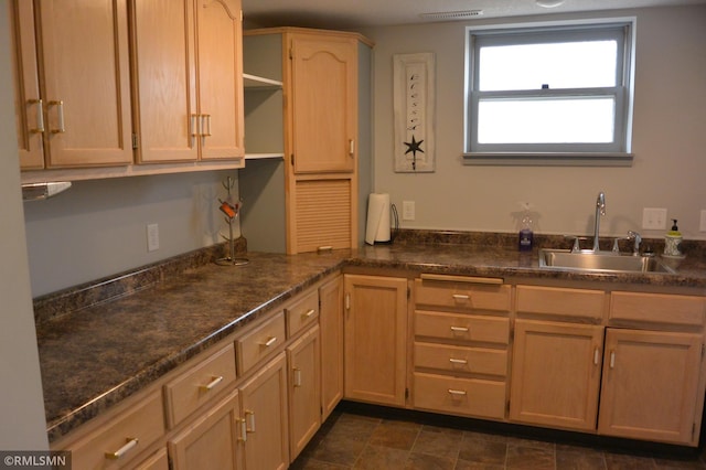 kitchen with light brown cabinetry and sink