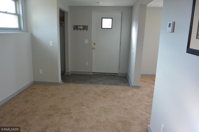 carpeted foyer entrance with a healthy amount of sunlight