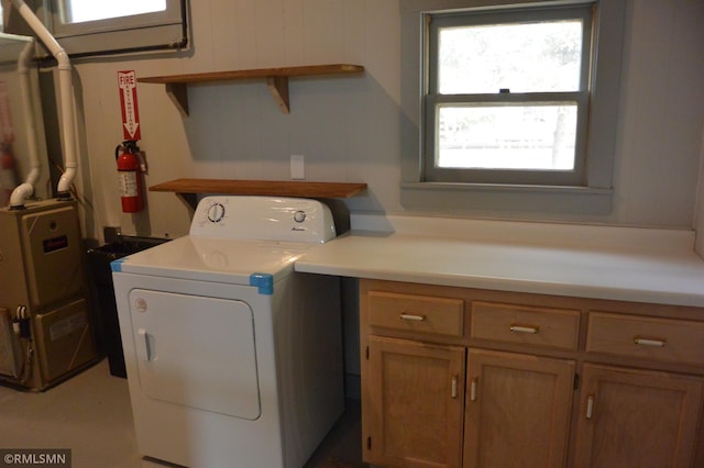 clothes washing area with washer / clothes dryer and cabinets