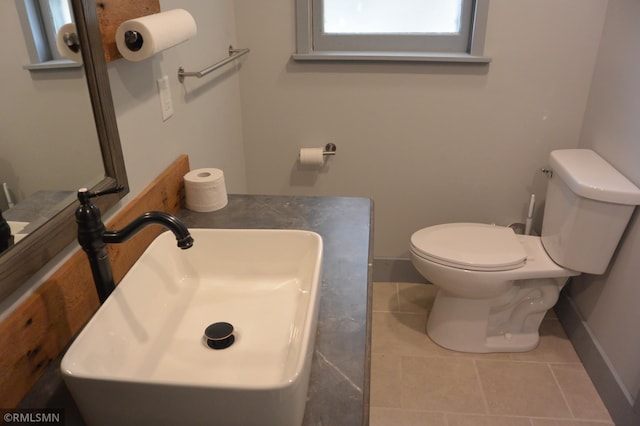 bathroom featuring toilet, sink, and tile patterned floors