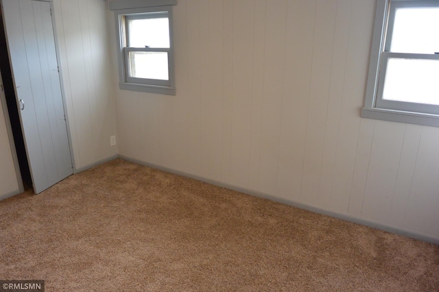 carpeted empty room with wooden walls