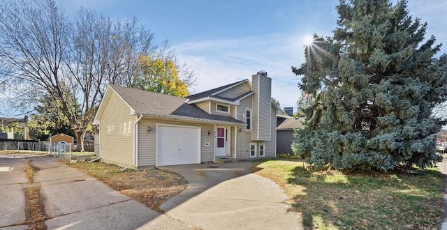 view of front of property with concrete driveway, a chimney, roof with shingles, an attached garage, and fence