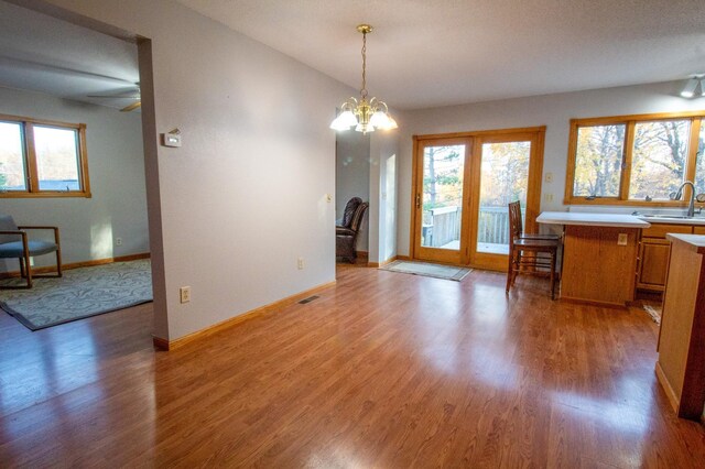 dining room with sink, wood-type flooring, and a chandelier