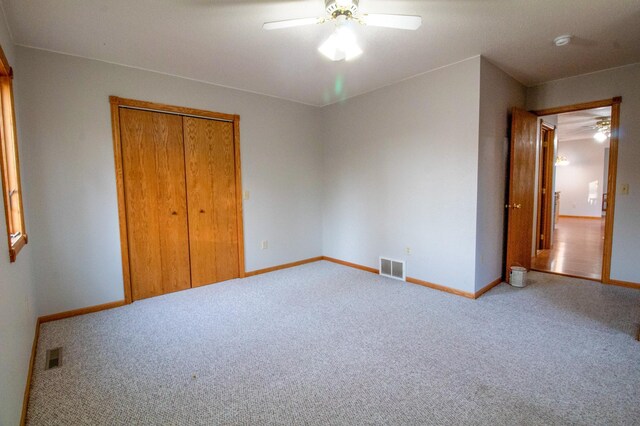 unfurnished bedroom featuring a closet, carpet flooring, and ceiling fan