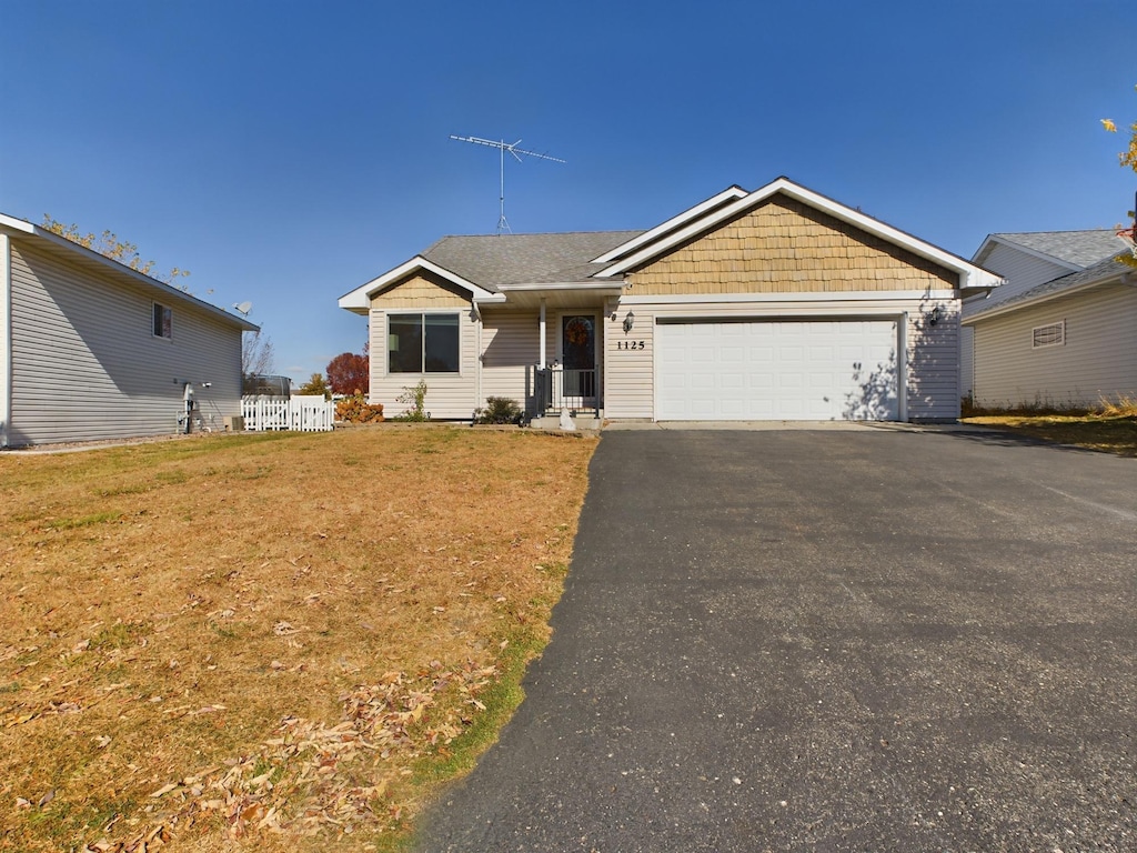 single story home featuring a front yard and a garage