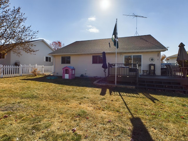 back of property with a wooden deck and a yard