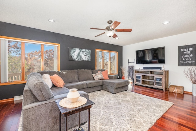 living room featuring a textured ceiling, dark wood-type flooring, a baseboard radiator, and ceiling fan