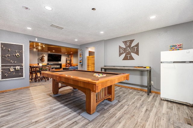 rec room with billiards, a textured ceiling, and light hardwood / wood-style floors