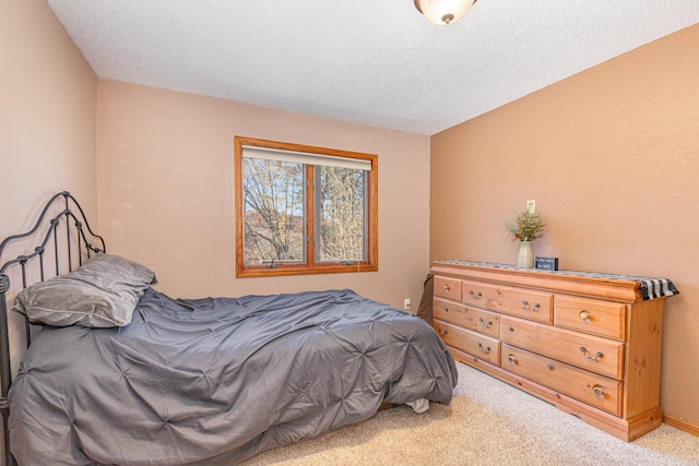 bedroom with light carpet and a textured ceiling