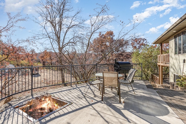 view of patio featuring an outdoor fire pit, a wooden deck, and a grill