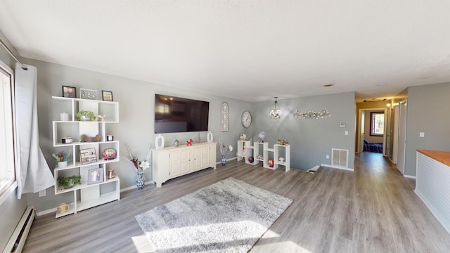 living room with baseboard heating and light wood-type flooring