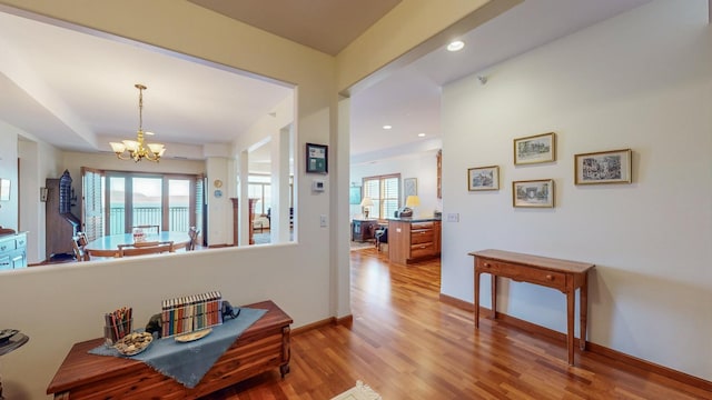 hall featuring a notable chandelier and light hardwood / wood-style flooring