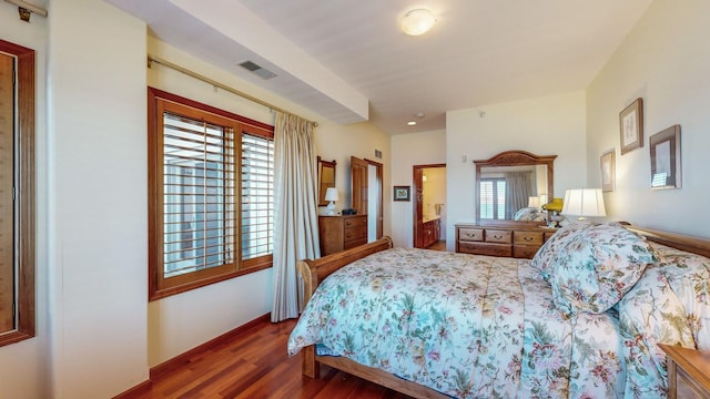 bedroom with multiple windows and dark hardwood / wood-style flooring