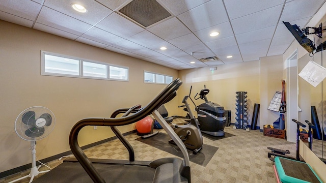 exercise area featuring carpet flooring and a drop ceiling