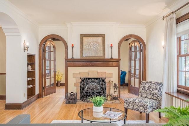 sitting room featuring a fireplace, french doors, ornamental molding, and hardwood / wood-style floors