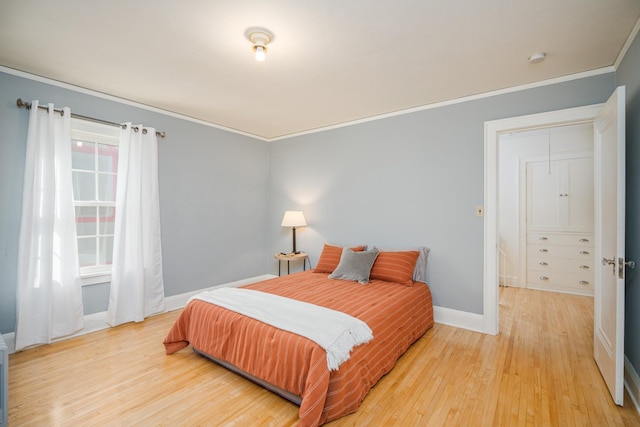 bedroom with ornamental molding and light wood-type flooring