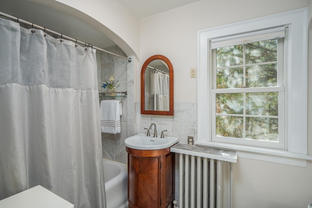 bathroom featuring radiator heating unit, vanity, tile walls, and shower / tub combo with curtain