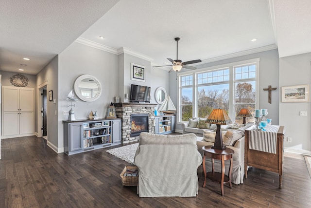 living room featuring dark wood-type flooring, ornamental molding, a textured ceiling, a fireplace, and ceiling fan