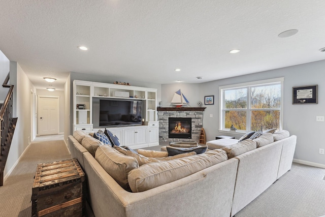 living room with light carpet, a textured ceiling, and a fireplace