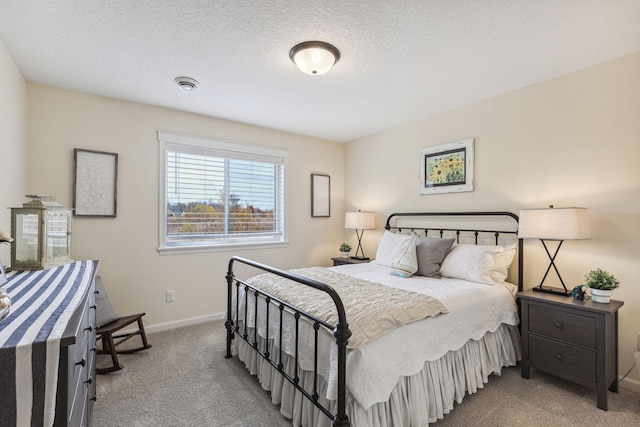 bedroom featuring a textured ceiling and light colored carpet