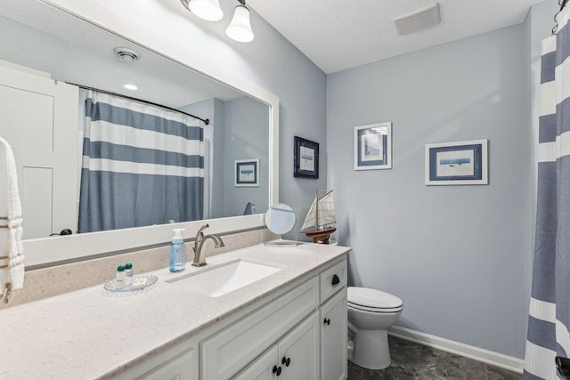 bathroom with vanity, toilet, and a textured ceiling