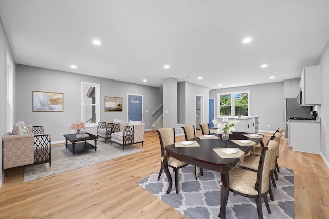 dining area with sink and light wood-type flooring