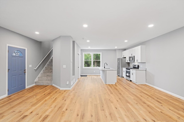 unfurnished living room featuring light hardwood / wood-style floors and sink