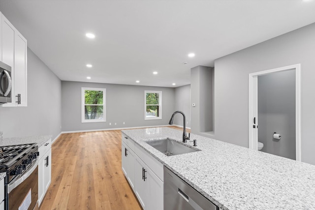 kitchen featuring white cabinets, light stone countertops, sink, and stainless steel appliances