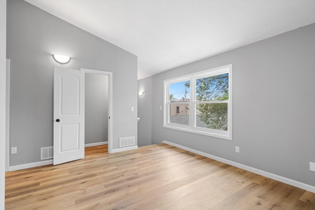 unfurnished bedroom featuring light wood-type flooring and vaulted ceiling