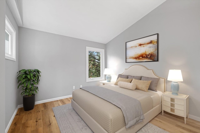 bedroom featuring lofted ceiling and light hardwood / wood-style flooring