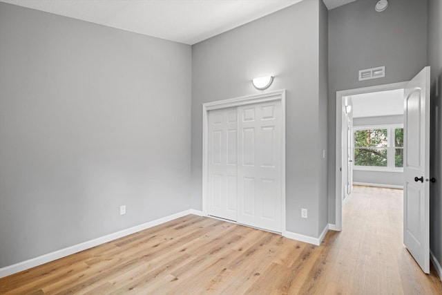 unfurnished bedroom with light hardwood / wood-style floors and a closet