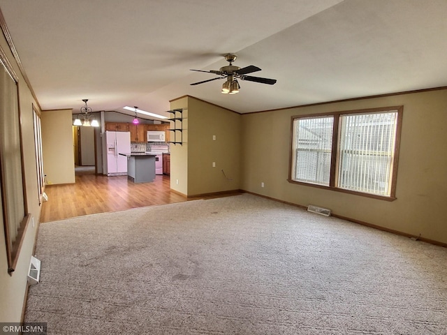 13658 Clearwater Forest Cir, South Haven, MN 55382 - unfurnished living room featuring light carpet, ceiling fan with notable chandelier, baseboards, lofted ceiling, and visible vents