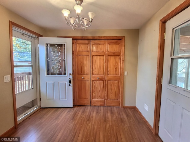 foyer with hardwood / wood-style flooring and an inviting chandelier