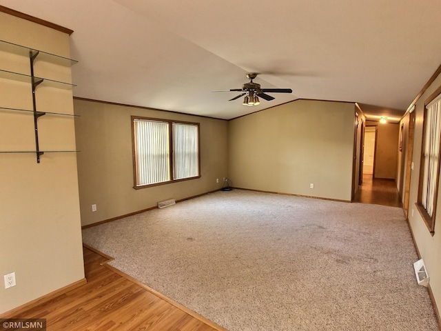 unfurnished room with ceiling fan, vaulted ceiling, and light wood-type flooring