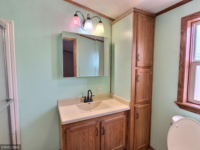 bathroom with vanity, ornamental molding, and toilet