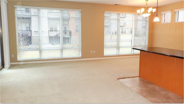 unfurnished dining area with light carpet and a chandelier