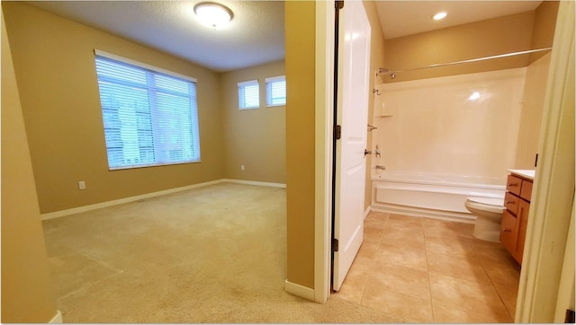 full bathroom featuring toilet, tile patterned flooring,  shower combination, vanity, and a textured ceiling