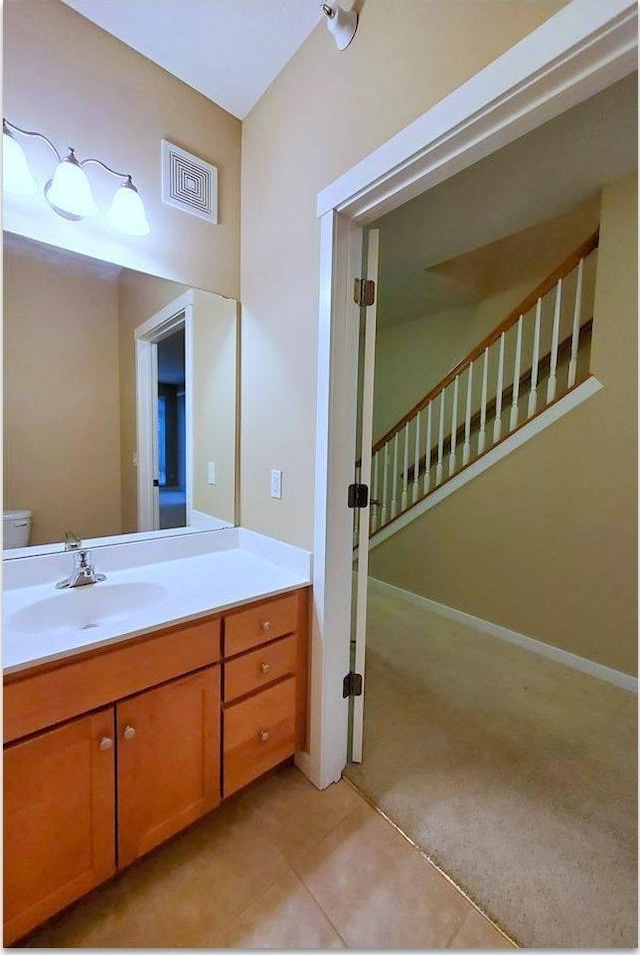 bathroom with vanity, toilet, and tile patterned flooring