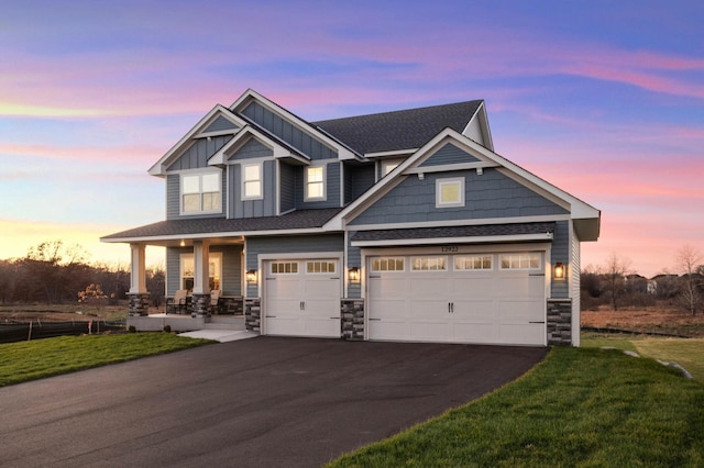 craftsman-style home featuring a yard, a porch, and a garage