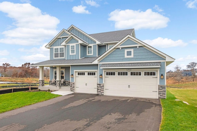 craftsman-style house featuring a front yard and a garage