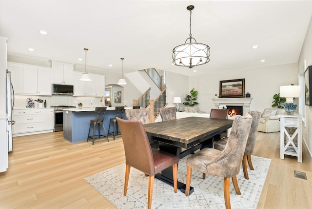 dining room with a notable chandelier and light wood-type flooring