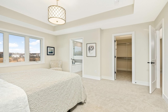 carpeted bedroom with a closet, ensuite bathroom, and a walk in closet