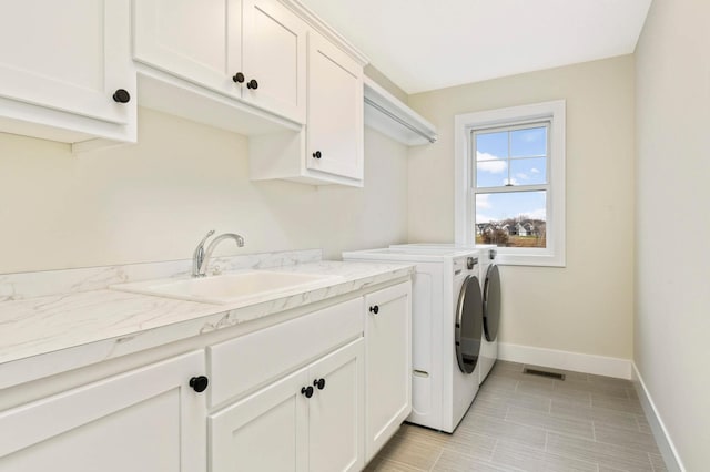 washroom with sink, washer and clothes dryer, and cabinets