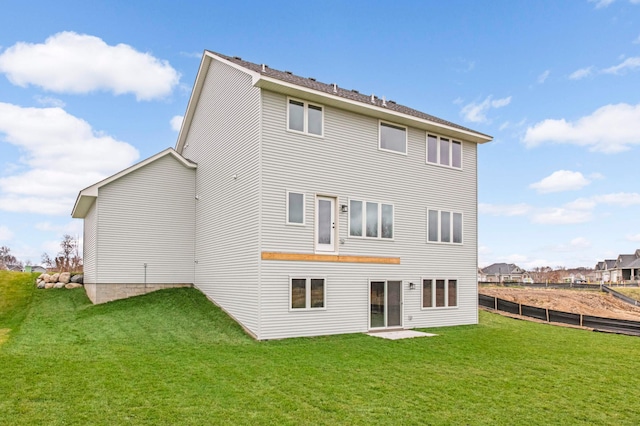 rear view of property featuring a lawn