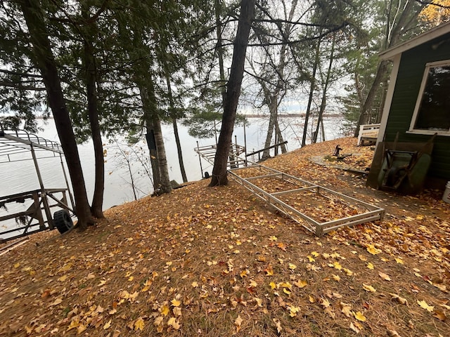 view of yard featuring a water view and a dock