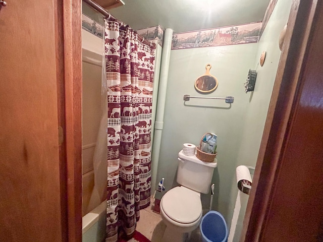 bathroom featuring toilet and shower / tub combo with curtain